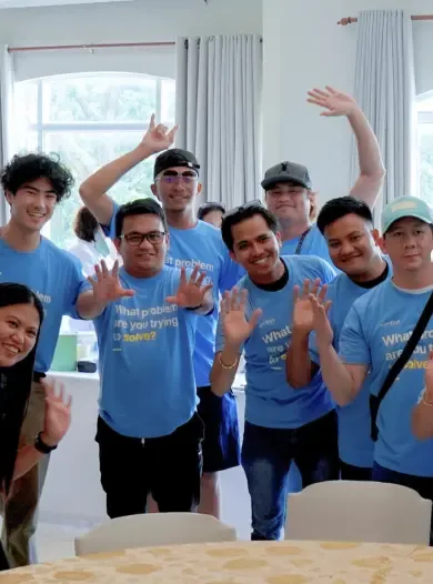 Nimbyx team members smiling and waving at the camera during a company event.